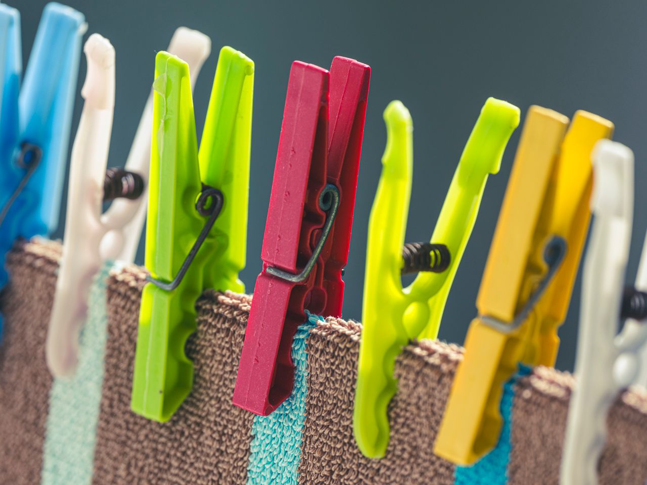 Vivid clothespins hang clothes on a line, showcasing laundry lifestyle essentials.